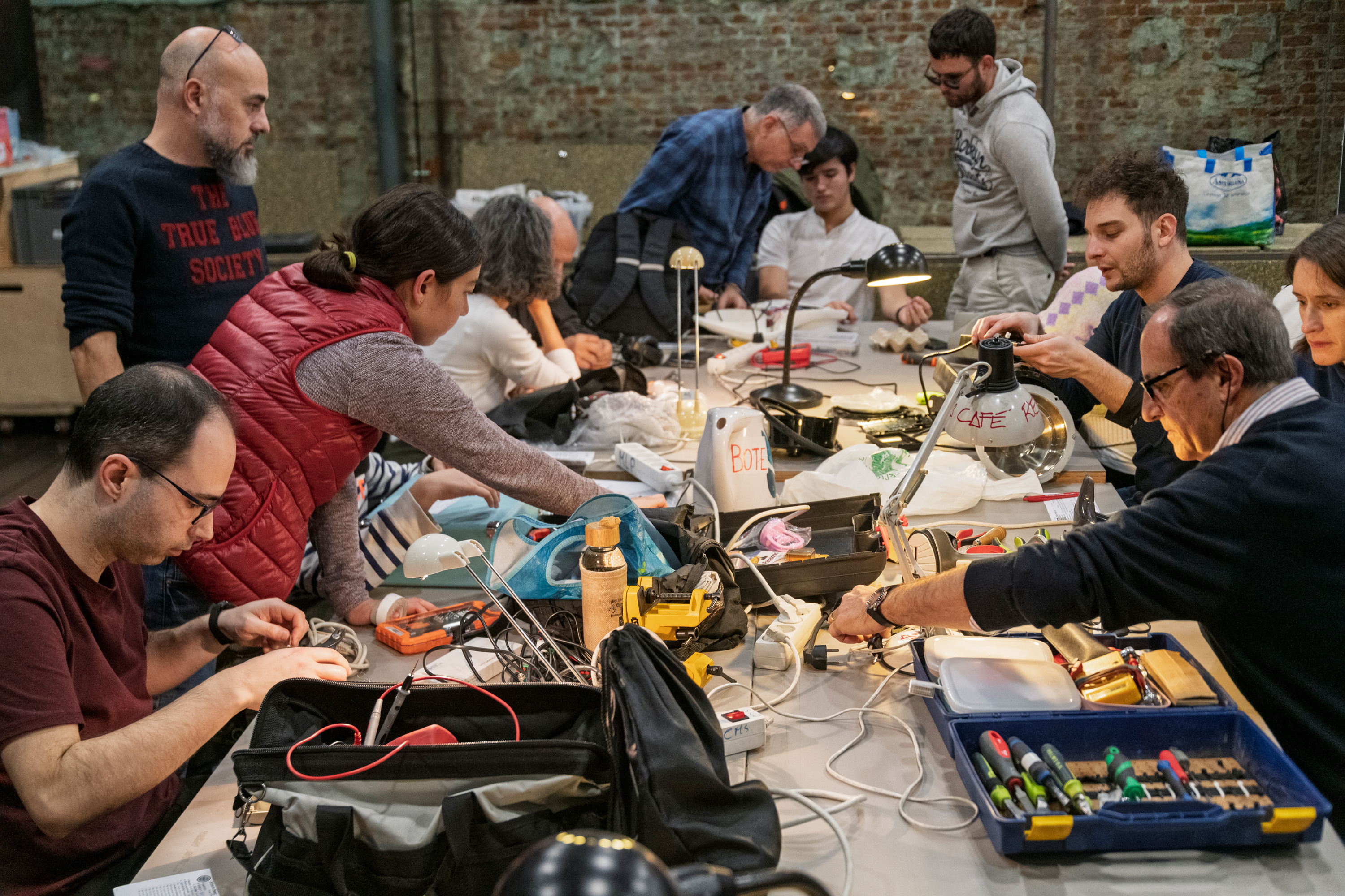 Gente repara aparatos electrónicos sobre una mesa